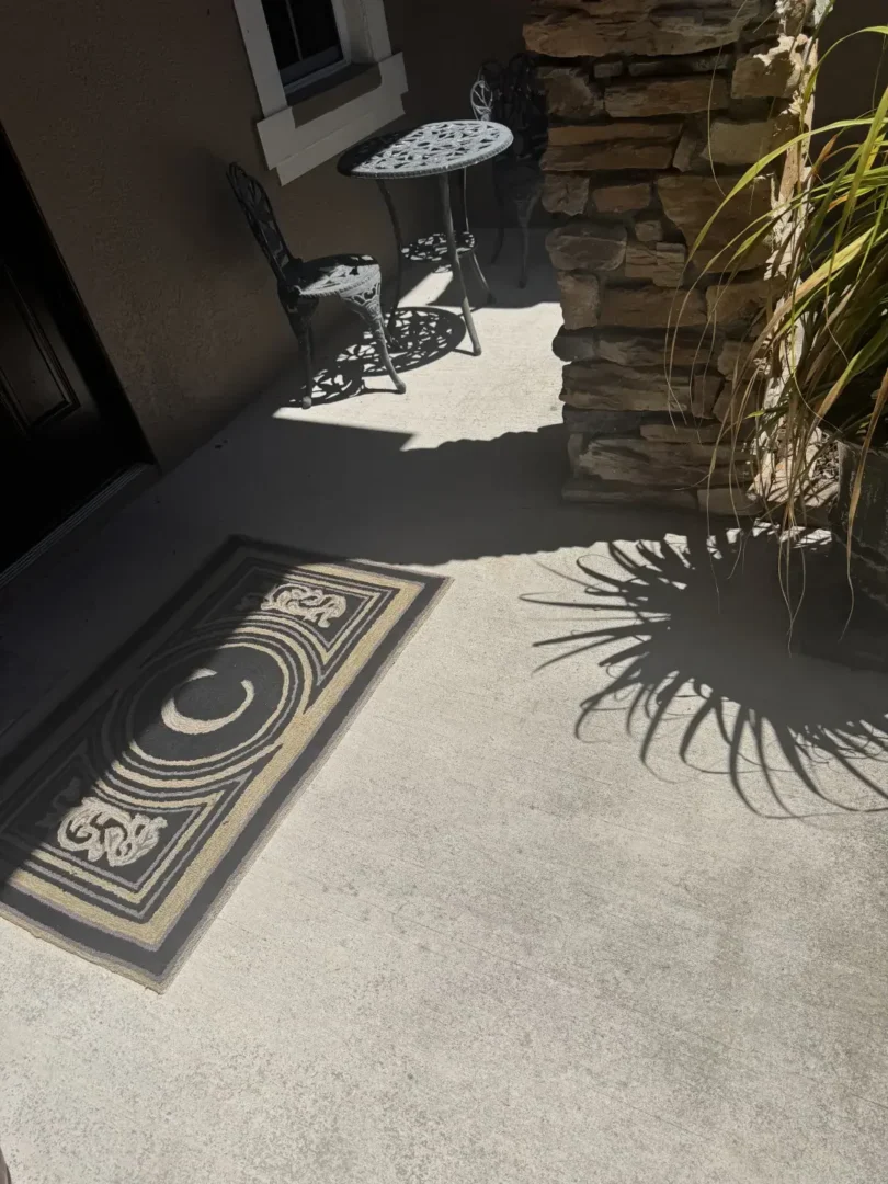 How Did Our Tile Floor Installation Transform This Front Entry in Odessa, FL? Porcelain tile floor installed on a residential front entryway in Odessa, FL with stone columns and landscaping