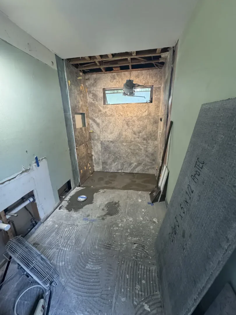 Let's Transform Your Bathroom Together Bathroom renovation in progress with tiled shower walls, exposed ceiling framing and unfinished floor